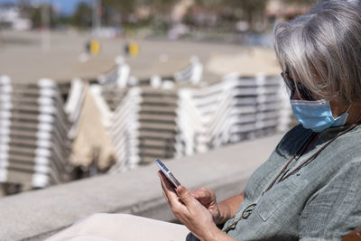 Rear view of man using mobile phone