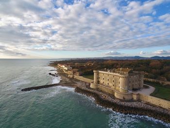 High angle view of old fort by sea against cloudy sky