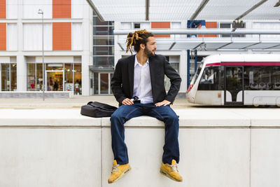 Young businessman with dreadlocks waiting at station