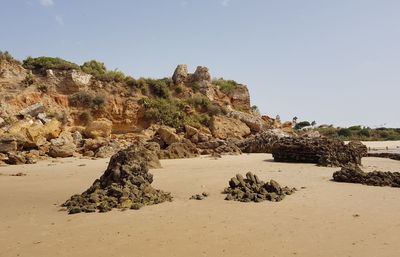 Rock formation on beach against clear sky