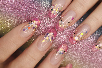 Close-up of woman hand on purple flowers