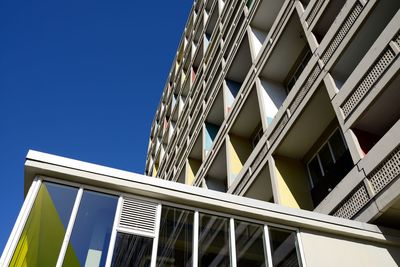 Low angle view of modern building against clear blue sky