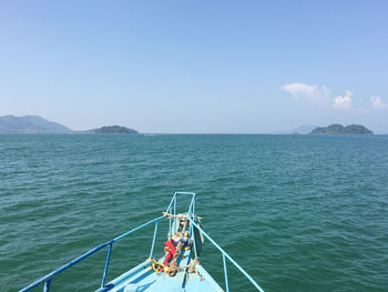 People on boat in sea against sky