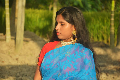 Woman looking away while standing on land