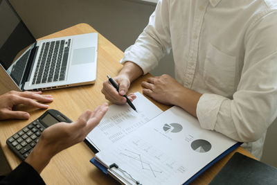 Midsection of businessman working at desk in office