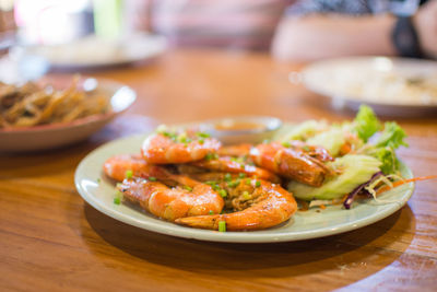 Close-up of cooked prawns served in plates on table