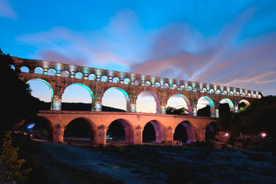 Arch bridge against sky at dusk