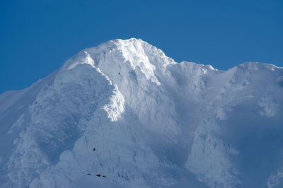 Scenic view of snowcapped mountains against clear blue sky