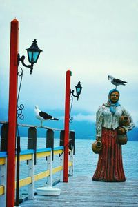 High angle view of lamp post by sea against sky