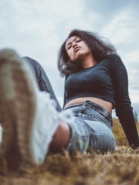 Portrait of a smiling young woman lying on field