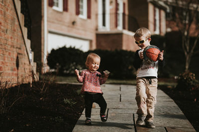 Portrait of children walking on footpath