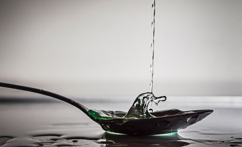 Close-up of water splashing in spoon at table