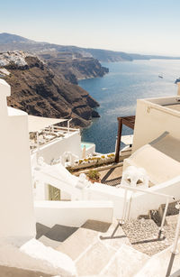 Scenic view of sea by mountain against sky