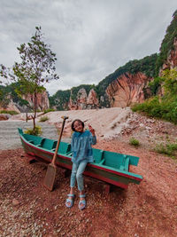 Rear view of woman sitting on bench at lakeshore