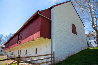 Colonial american whitewashed stone barn with red wood trim