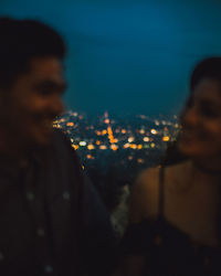 Portrait of man in city against sky at night