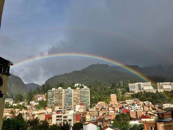 Scenic view of rainbow over residential district