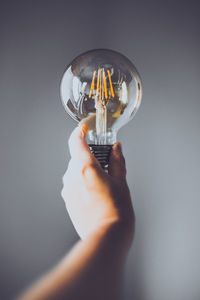 Close-up of hand holding light bulb