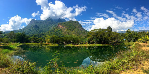 Scenic view of lake by mountains against sky