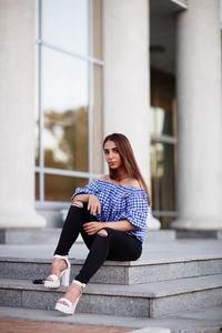 Portrait of young woman sitting on staircase