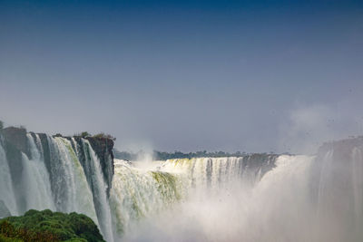 Scenic view of waterfall against sky