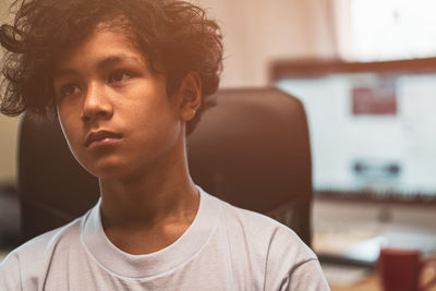 Portrait of young man looking away at home