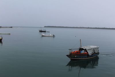 Boat moored in sea against clear sky