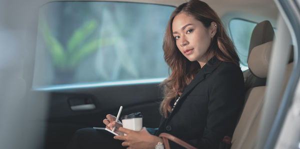 Young woman looking away while sitting in car