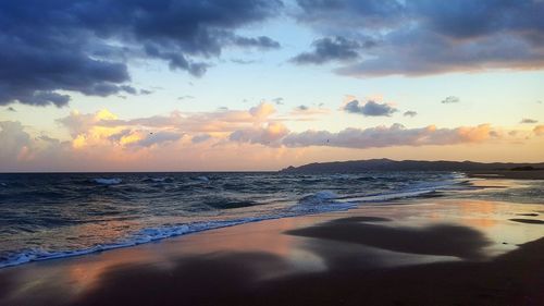 Scenic view of beach against sky during sunset