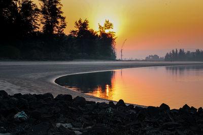 Scenic view of lake against orange sky