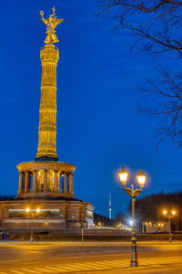 The famous victory column with a street light and tree branches in berlin, germany, at night