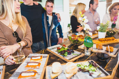 Food on table with friends in background at restaurant