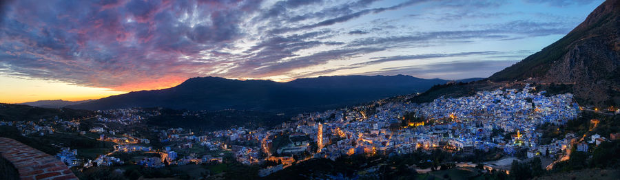 Panoramic view of buildings against cloudy sky