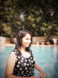 Portrait of young woman looking at swimming pool