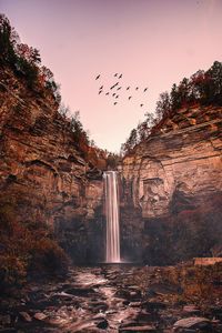 Scenic view of waterfall against sky