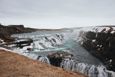 Scenic view of waterfall against sky
