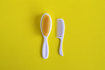 High angle view of fork over yellow background