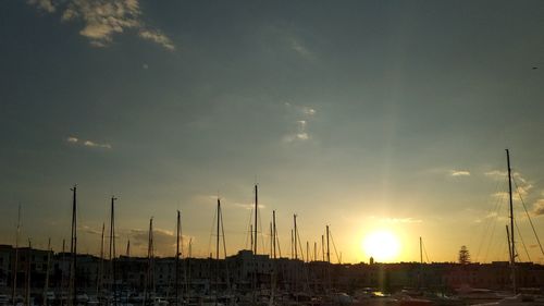 Silhouette of cranes against sky during sunset