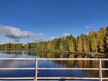 Scenic view of lake by trees against sky