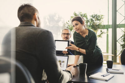 Businesswoman presenting her ideas on digital tablet to manager in office