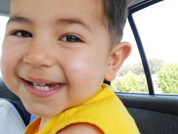 Portrait of cute boy smiling in car