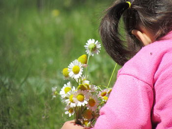 Rear view of girl picking yellow flowers