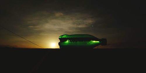 Low angle view of illuminated light against sky at sunset