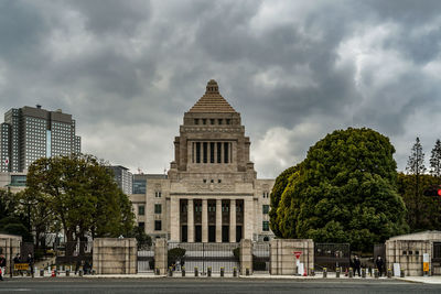 Buildings in city against cloudy sky