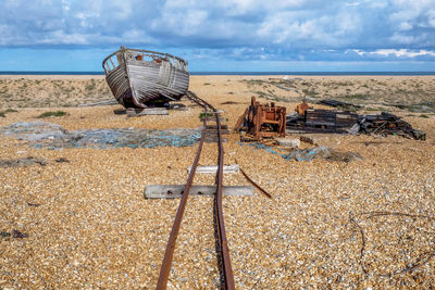 Abandoned truck on beach against sky