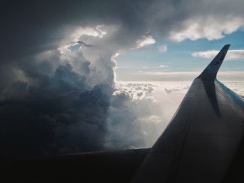 Airplane wing over storm clouds