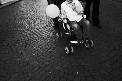 Low section of person with balloon and ice cream on wheelchair