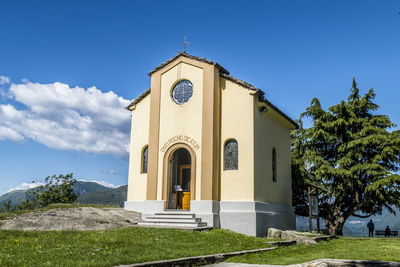 Church by building against blue sky