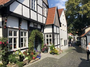 Houses by street amidst buildings in city