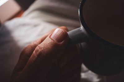 Close-up of hand holding coffee cup